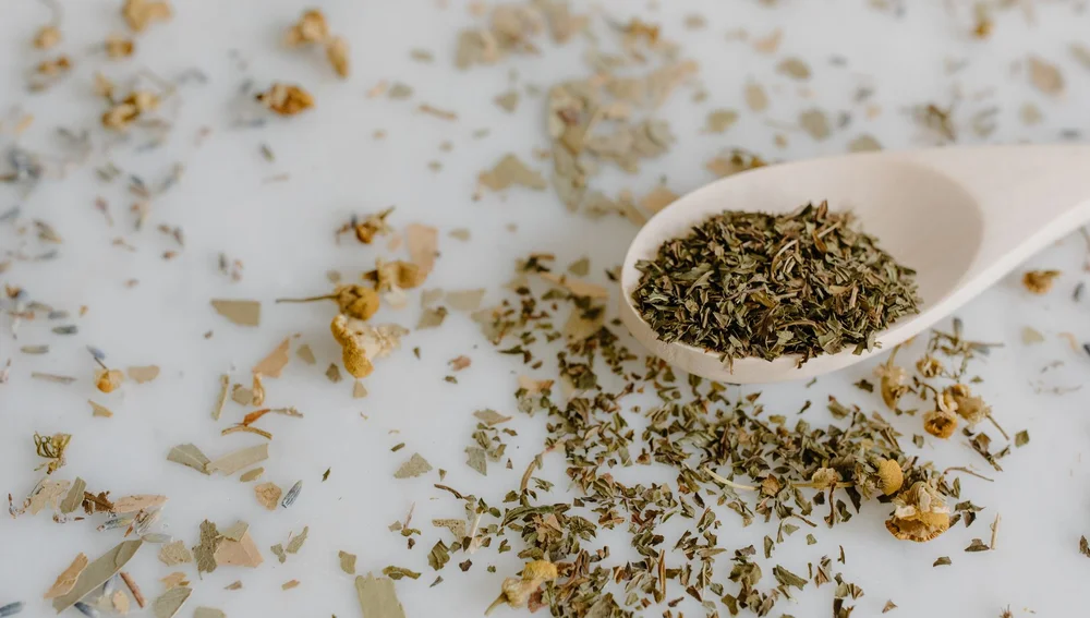 Bahan herbal adaptogen di atas sendok kayu untuk minuman kesehatan